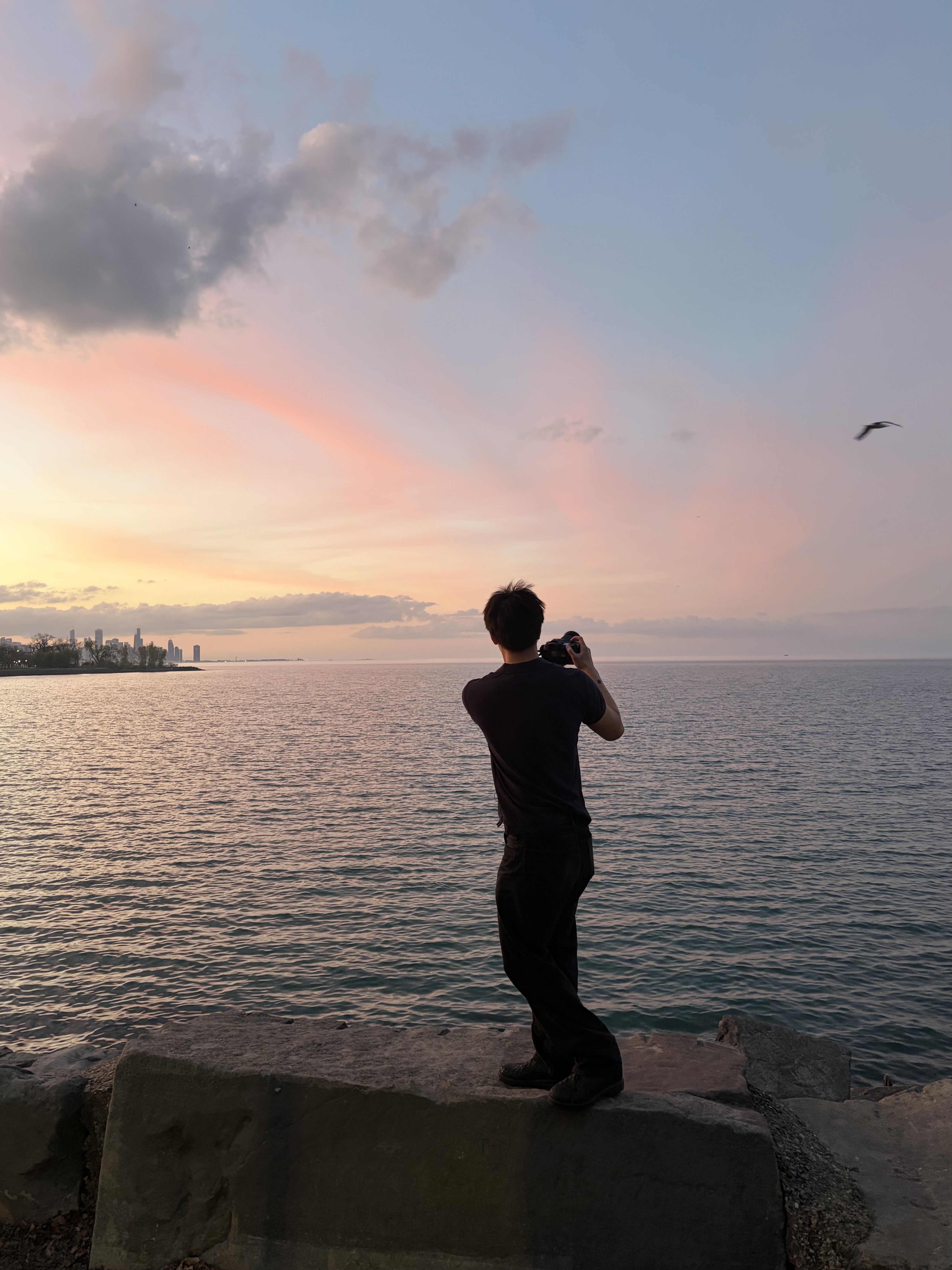Max Shen photographing a sunset over the water